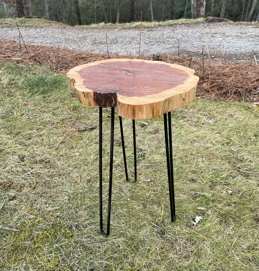 The side table pictured is made from hand-shaped metal hairpin legs and a handmade live edge cedar slab with a food safe finish. 